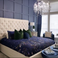 a blue and white bedroom with a chandelier